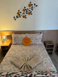 a bedroom with a bed with a headboard and a flower mural at Inspire GuestHouse in Campos do Jordão