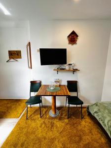 comedor con mesa, sillas y TV en Slovenian House Vida en Bled