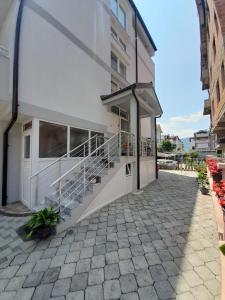 - un bâtiment blanc avec des escaliers sur son côté dans l'établissement Vila Bolonja, à Struga