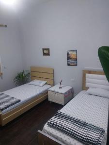 1 dormitorio con 2 camas y mesa. en A&A House, en Berat