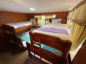 2 łóżka piętrowe w pokoju z oknem w obiekcie Playita Salomon w Baños