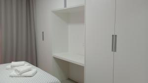 a bedroom with a bed and a white cabinet at RED DESIGN - Apto completo 2 Qts 901 in Vitória