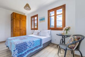 ein Schlafzimmer mit einem Bett, einem Tisch und einem Stuhl in der Unterkunft Villa Daphne in Skopelos + 32 Fotos