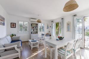 ein Wohnzimmer mit einem weißen Tisch und Stühlen in der Unterkunft Villa Daphne in Skopelos