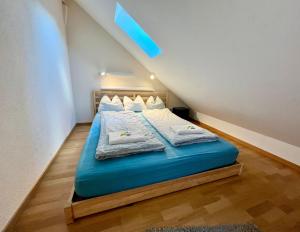 a bedroom with a blue bed with towels on it at Apartments Aarbergergasse - Self Check-In in Bern