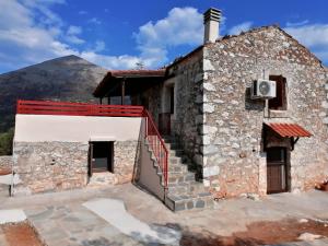 una casa de piedra con una montaña en el fondo en Xemoni House, en Koíta