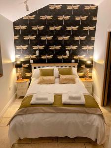 a bedroom with a large bed with towels on it at Tranquil retreat with hot tub in Stoke Bruerne