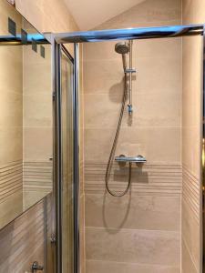 a shower with a hose in a bathroom at Tranquil retreat with hot tub in Stoke Bruerne