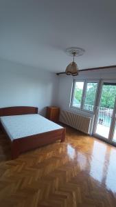 une chambre avec un lit et deux fenêtres dans l'établissement M-EDEN House, à Belgrade