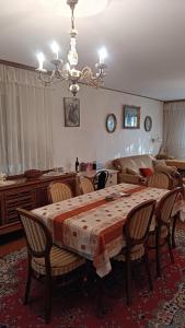 une salle à manger avec une table, des chaises et un lustre dans l'établissement M-EDEN House, à Belgrade