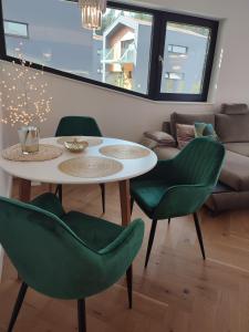 salon ze stołem i zielonymi krzesłami w obiekcie Luxe chalet 79 w Rużomberku