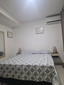 1 dormitorio con 1 cama en una habitación blanca en Souza Lofts Centro Praça Tiradentes, en Teófilo Otoni