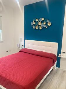 - une chambre avec un lit rouge et un mur bleu dans l'établissement La Bussola Airport Affitta Camere, à San Giovanni Teatino