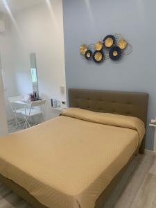 ein Schlafzimmer mit einem Bett mit zwei Platten an der Wand in der Unterkunft La Bussola Airport Affitta Camere in San Giovanni Teatino
