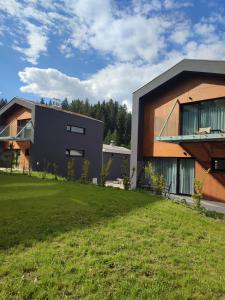 a house with a green lawn in front of it at Luxe chalet 79 in Ružomberok