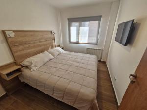 um pequeno quarto com uma cama e uma janela em Casa Laura Bariloche em San Carlos de Bariloche