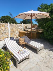 two lounge chairs and an umbrella on a patio at Maison Fruitier with pool at 15m from the Beach in Sainte-Maxime