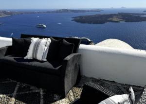 a couch on a balcony with a view of the water at Exquisite Santorini Villa Villa Kamelot 3 Bedrooms Spectacular Aegean Sea Views Private Outdoor Hot Tub Imerovigli in Imerovigli