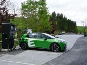 Modriach的住宿－Gasthof Klug zum Ehrensepp，一辆绿色汽车在燃气泵上充电