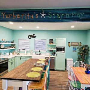 a kitchen with a table with chairs and a refrigerator at Yarbarita's Stay and Play in Rockport