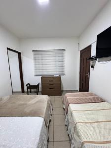 a hotel room with two beds and a flat screen tv at Acogedor independiente-Casa JH A in Santa Cruz de la Sierra