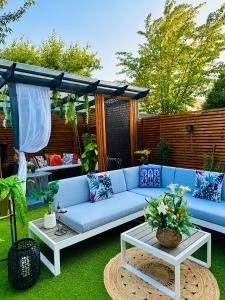un patio con un sofá azul en el césped en MeeZee Pearl Double Bed Lodge With Free Parking en Mánchester