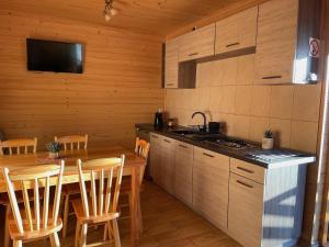 a kitchen with a wooden table and a table and chairs at Domki Alex in Dębki +37 photos