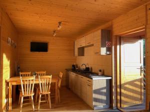 a kitchen and dining room with a table and chairs at Domki Alex in Dębki