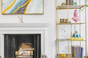 a living room with a fireplace and a painting at Flat in Chelsea in London