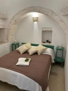 - une chambre avec un grand lit et 2 tables de chevet vert dans l'établissement Trullo Gemma, à Martina Franca