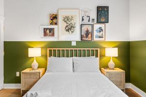 a bedroom with green walls and a bed with two lamps at Sosuite at The Loxley - Old City in Philadelphia