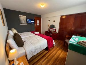 1 dormitorio con 1 cama con manta roja en St. Gallen Haus, en Quito