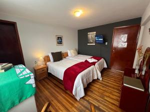 1 dormitorio con 1 cama con manta roja en St. Gallen Haus, en Quito