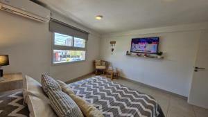 ein Schlafzimmer mit einem Bett und einem TV an der Wand in der Unterkunft DEPARTAMENTO TAG in Santiago del Estero