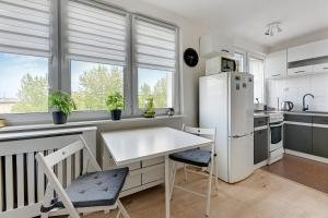 a kitchen with a white refrigerator and a table at Wave Apartments - Aurora in Gdynia