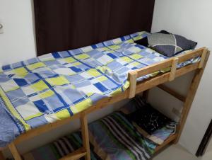a bunk bed with a blue and yellow quilt on it at Boarding house in Guinauayan +3 photos