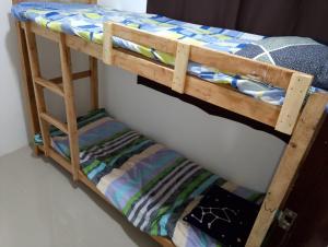 a bunk bed with a wooden bunk bed frame at Boarding house in Guinauayan