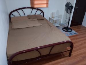 a bed with a wooden frame in a room at Boarding house in Guinauayan