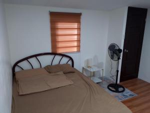 a bedroom with a bed in a room with a fan at Boarding house in Guinauayan
