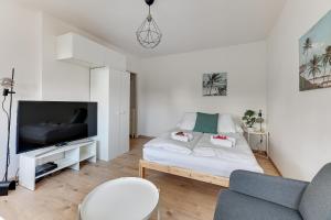 a living room with a bed and a tv at Wave Apartments - Aurora in Gdynia