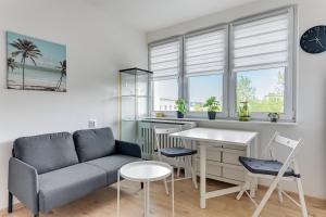 a living room with a couch and a table at Wave Apartments - Aurora in Gdynia +8 photos