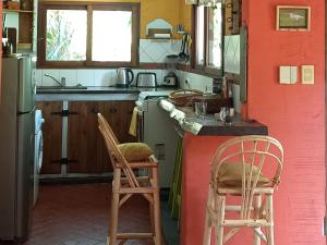 a kitchen with two chairs and a red wall at Casa Bendita Pacha in Mar del Plata