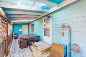 a room with a table and a refrigerator on a porch at Blue Heaven Beach House in Rockaway Beach