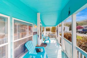 a blue house with two blue chairs on a porch at Blue Heaven Beach House in Rockaway Beach