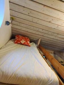 Skåne-TranåsにあるCharming cottage in a beautiful landscapeの赤い枕付きのベッドが備わる客室です。