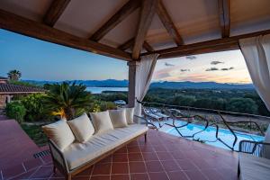 a patio with a couch and a view of a pool at Villa Capo Coda Cavallo piscina privata in San Teodoro