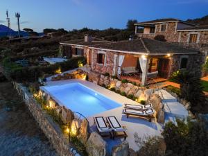 a swimming pool with two lounge chairs and a house at Villa Capo Coda Cavallo piscina privata in San Teodoro