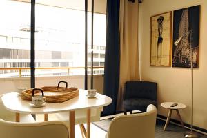 Habitación con mesa, sillas y ventana en Living Paris en Santiago