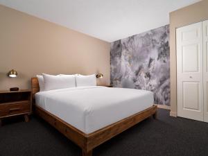 a bedroom with a large white bed and a painting at Huntingdon Hotel and Suites in Victoria +37 photos