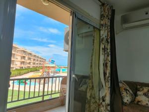 a room with a balcony with a view of a pool at دلتا مارينا in Al Ḩammād